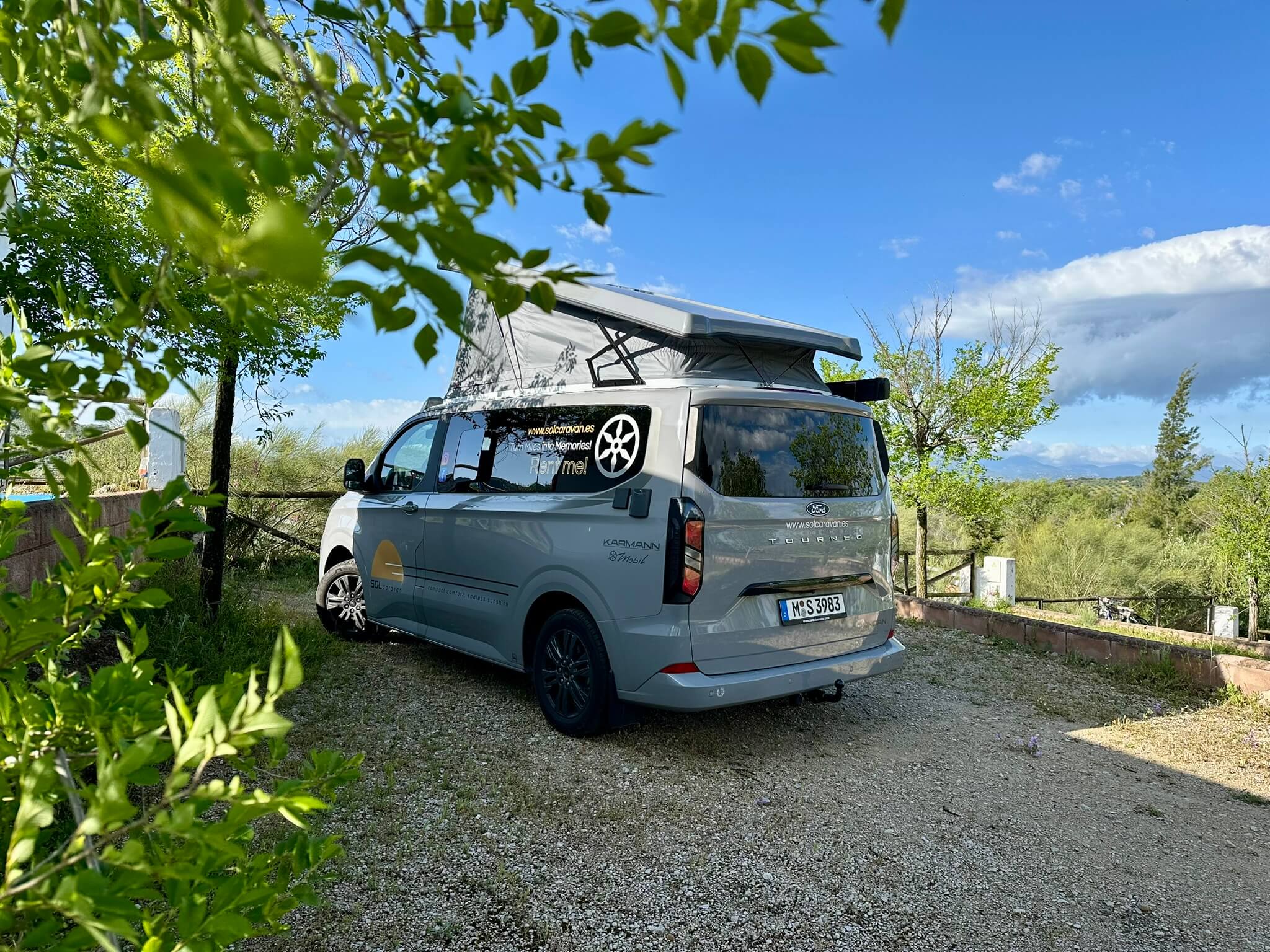 Duncan 500 camper van parked in a serene forest, surrounded by lush green trees and nature.