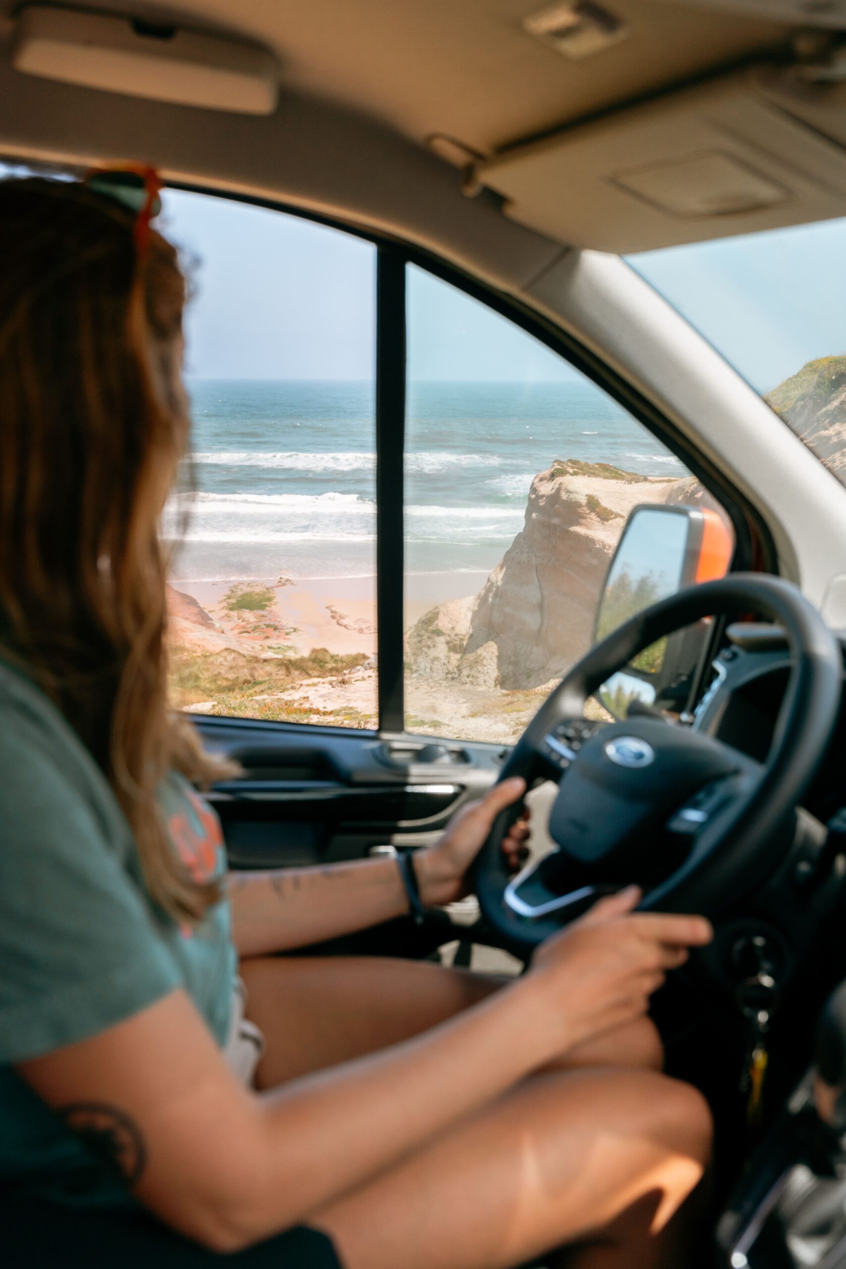 Campervan driving nex to the sea by woman